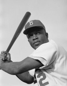 Brooklyn Dodgers baseball player Jackie Robinson prepares to swing his bat for a photo in 1954.