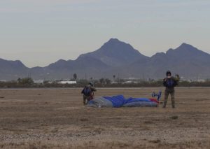 U.S. Air Force Airmen assigned to the 563rd Rescue Group pack their parachutes after landing at Davis-Monthan Air Force Base