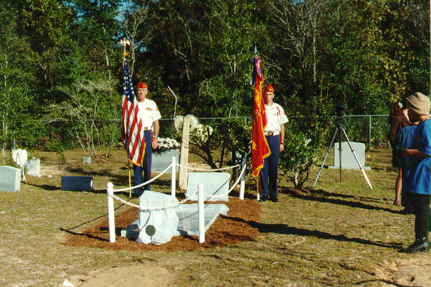 An honor guard holds the American and Marine Corps flags at the gravesite of Marine Corps Pfc. Robert Jenkins Jr.
