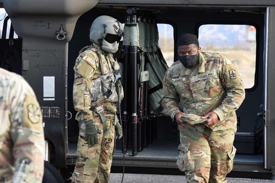Private 1st Class Theron Johnson, 1-158th Infantry Battalion, combat medic, disembarks from a UH-60 Blackhawk
