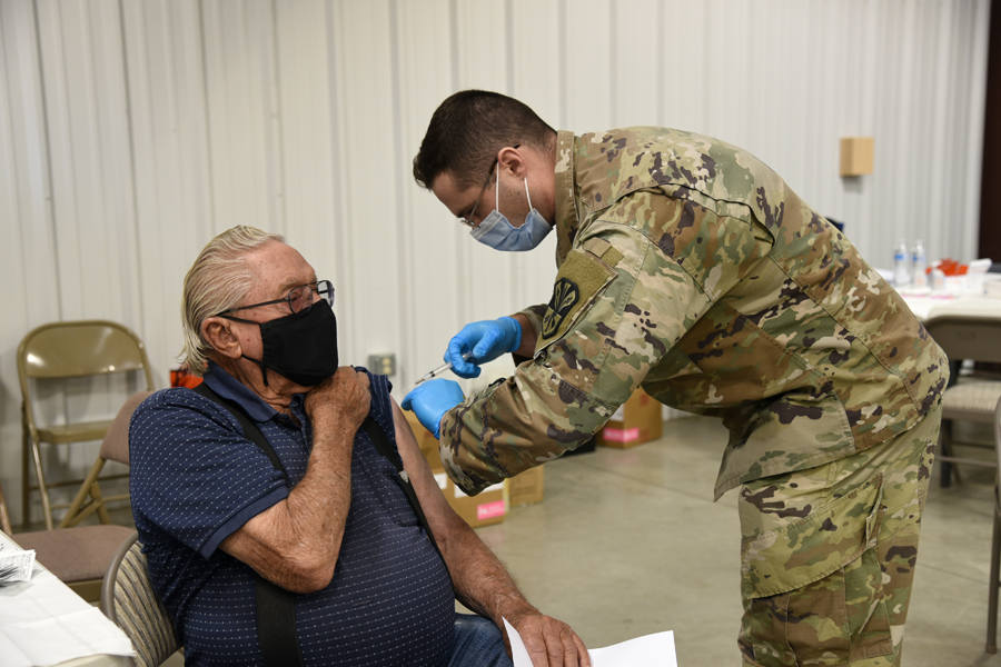 Spc. Matthew Wilcox, 996 Area Support Medical Company, combat medic, administers the COVID-19 vaccine