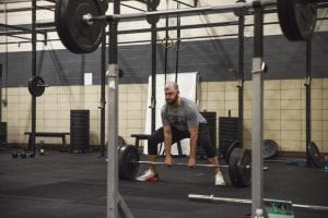 An athlete prepares to perform a power clean during a functional movement class