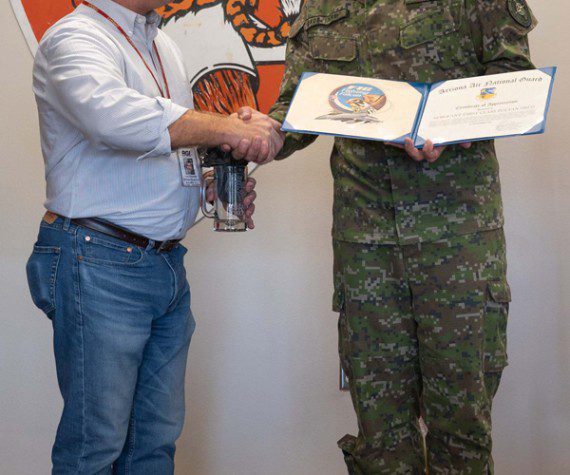 Michael Neighbors, 162nd Wing International Affairs, presents Slovak Liaison Officer assistant, Sgt. 1st Class Zoltan Okos, with a certificate of appreciation for his three years of service at Morris Air National Guard Base during a ceremony Nov. 21, 2022. 