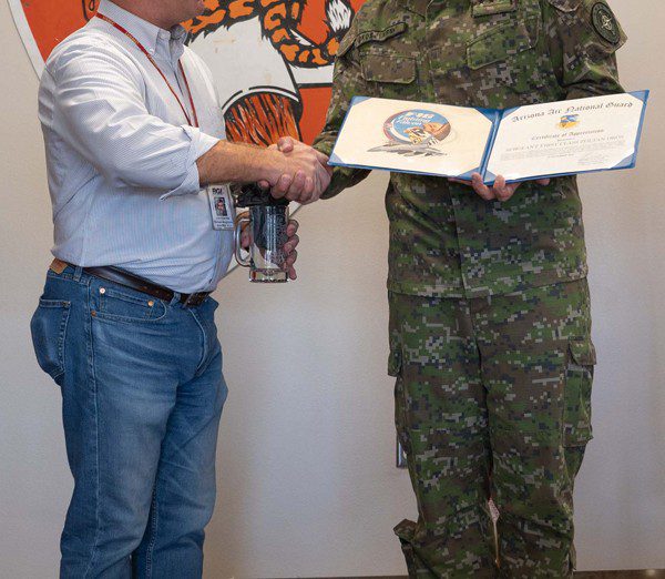 Michael Neighbors, 162nd Wing International Affairs, presents Slovak Liaison Officer assistant, Sgt. 1st Class Zoltan Okos, with a certificate of appreciation for his three years of service at Morris Air National Guard Base during a ceremony Nov. 21, 2022.