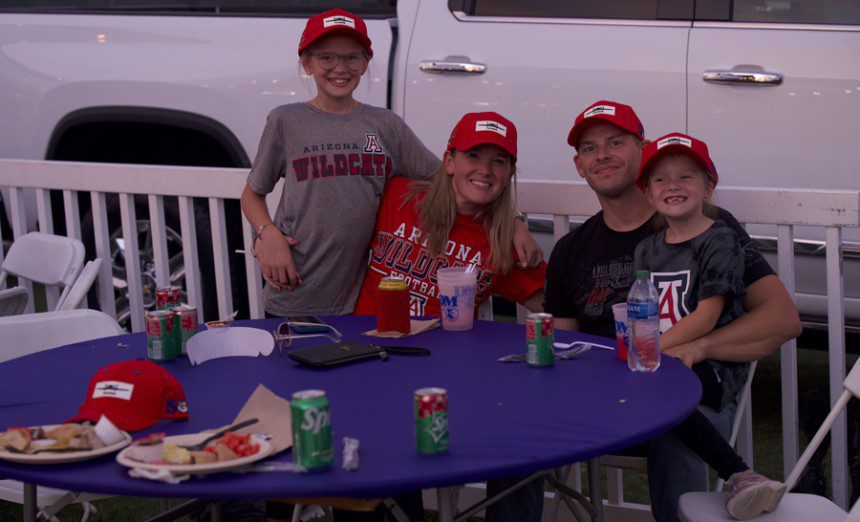 U.S. Air Force Master Sgt. Mark Doke, 355th Munitions Squadron armament maintenance section chief, sits with his family at the DM50 tailgate in Tucson, Ariz., Sept. 16, 2023. Airmen from Davis-Monthan Air Force base attended the DM50 tailgate with their families before the Wildcats game occurred in Arizona Stadium. (U.S. Air Force photo by Airman 1st Class Robert Allen Cooke III)