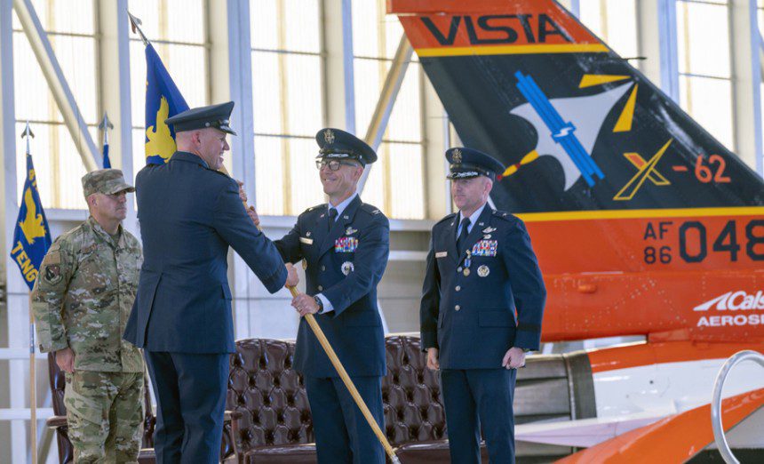 Maj. Gen. Evan C. Dertien, Air Force Test Center commander, passes the 412th Test Wing guidon to Col. Douglas P. Wickert, the wingís new commander, at a change of command ceremony Aug. 18, 2023, at Edwards Air Force Base, Calif. (Photograph by Dennis Anderson)