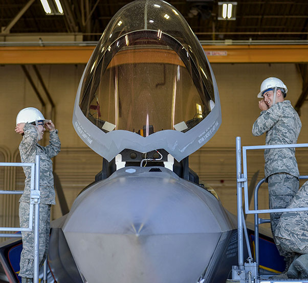 Air Force photograph by Airman 1st Class Caleb Worpel Airman 1st Class Raena Sadowski and Airman 1st Class Matthew Romano, 56th Component Maintenance Squadron egress systems technicians, put on safety helmets before the removal of an ejection seat from an F-35A Lightning II at Luke Air Force Base, Ariz., Jan. 11, 2018. In May 2017, three modifications were implemented to the F-35 ejection system to remove the 136 pound weight limit restriction.