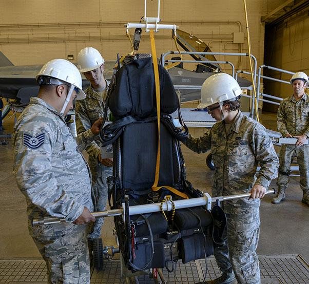 Air Force photograph by Airman 1st Class Caleb Worpel Airmen assigned to the 56th Component Maintenance Squadron guide an F-35A Lightning II ejection seat onto a cart for maintenance at Luke Air Force Base, Ariz., Jan. 11, 2018. In May 2017, three modifications were implemented to the F-35 ejection system to remove the 136 pound weight limit restriction.