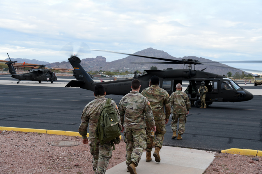 Arizona National Guard combat medics load into a UH-60 Blackhawk to be transported to a vaccination site