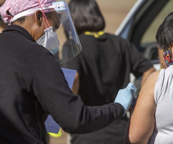 A Gila River Health Care worker administers a COVID-19 vaccination