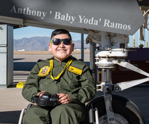 Anthony “Baby Yoda” Ramos, Pilot for a Day participant, sits in front of an F-35 Lightning II Dec. 16, 2021, at Luke Air Force Base, Ariz. During his visit, Ramos and his family learned about the 61st Fighter Squadron mission, visited the 56th Civil Engineer Squadron fire department and the 56th Operation Support Group aircrew flight equipment shop, and watched jets take off. (Air Force photograph by Senior Airman Leala Marquez)