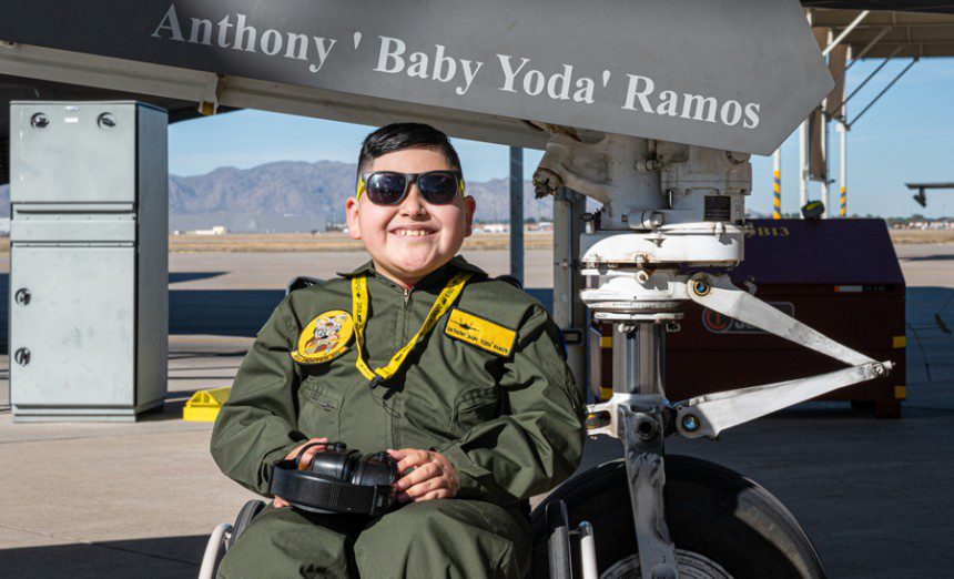 Anthony “Baby Yoda” Ramos, Pilot for a Day participant, sits in front of an F-35 Lightning II Dec. 16, 2021, at Luke Air Force Base, Ariz. During his visit, Ramos and his family learned about the 61st Fighter Squadron mission, visited the 56th Civil Engineer Squadron fire department and the 56th Operation Support Group aircrew flight equipment shop, and watched jets take off. (Air Force photograph by Senior Airman Leala Marquez)