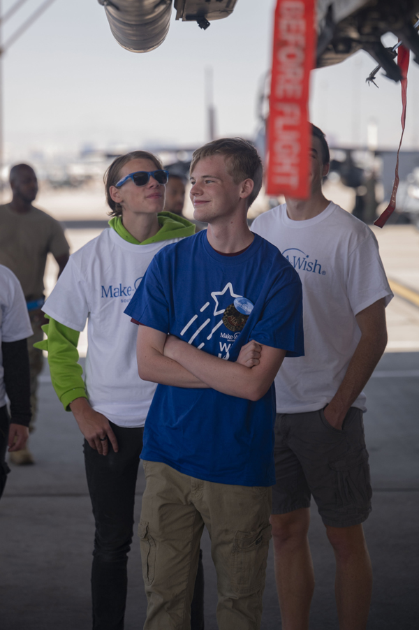 Joseph D., a child with the Make-A-Wish foundation, center, receives a tour of an F-15E Strike Eagle during his visit to Nellis Air Force Base, Nev., June 2, 2023. According to a Make-A-Wish Foundation study in 2010, wishes granted give “increased hope, strength, joy, confidence, self-esteem, quality of life, and well-being; serve as a coping mechanism and a turning point during treatment; brought families closer together and strengthened relationships with loved ones; and Helped overcome traumatic stress, hopelessness, depression, and loneliness.” (Air Force photograph by Senior Airman Zachary Rufus)