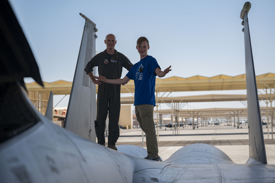 Maj. Aaron Hieronymus, 17th Weapons Squadron weapon systems officer, left, and Joseph D., a child with the Make-A-Wish foundation, tour an F-15E Strike Eagle at Nellis Air Force Base, Nev., June 2, 2023. (Air Force photograph by Senior Airman Zachary Rufus)