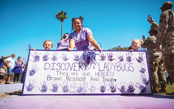 Children and caretakers from the Luke Air Force Base Child Development Center pose for a photo during a Purple Up parade, April 19, 2024, at Luke AFB, Arizona. Purple represents the joint branches and the military children that sacrifice alongside service members across the Department of Defense. Events like this contribute to increasing quality of life at Luke AFB by honoring the military members and their children. (U.S. Air Force photo by Airman 1st Class Katelynn Jackson)
