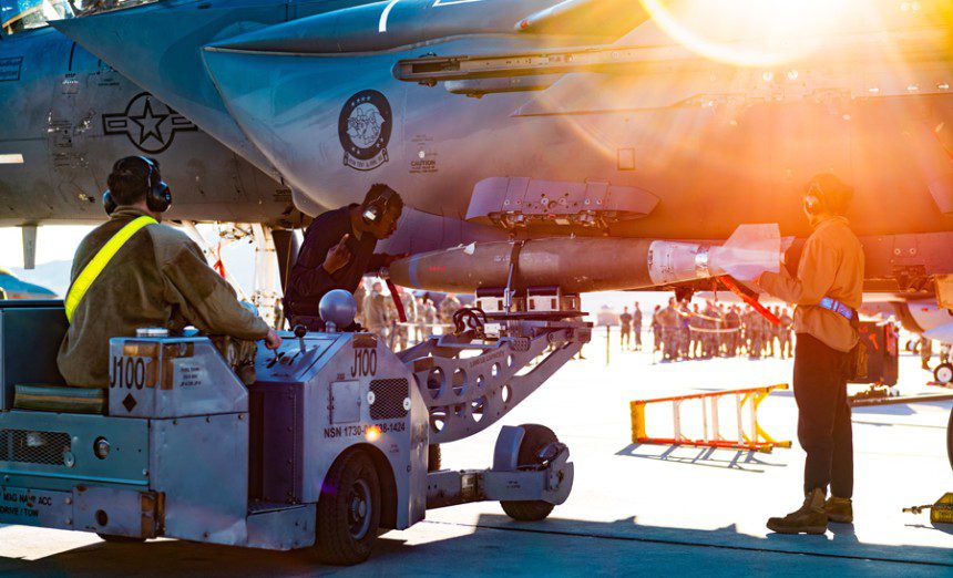 Airmen from the 57th Aircraft Maintenance Squadron install munitions during the 4th quarter load competition at Nellis Air Force Base, Nevada, Oct. 15th, 2021. Load comp is a demonstrative competition between crews to ensure readiness and proper munition handling while racing against the clock. (U.S. Air Force photo by Senior Airman Sean Hetz.)