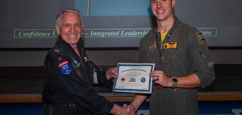 Capt. Paul Young, a pilot assigned to the 336th Fighter Squadron, Seymour Johnson, N.C., accepts the Capt. John Stone award for ‘Outstanding Mission Commander’ by its namesake, retired Col. John “JB” Stone, during the Red Flag-Nellis 22-3 culmination ceremony at Nellis Air Force Base, Nev., July 28, 2022. The Capt. John Stone award is the mark of influential and quintessential planning that will lead the Air Force into surpassing its near-peer challengers. (Air Force photograph by Airman 1st Class Josey Blades)