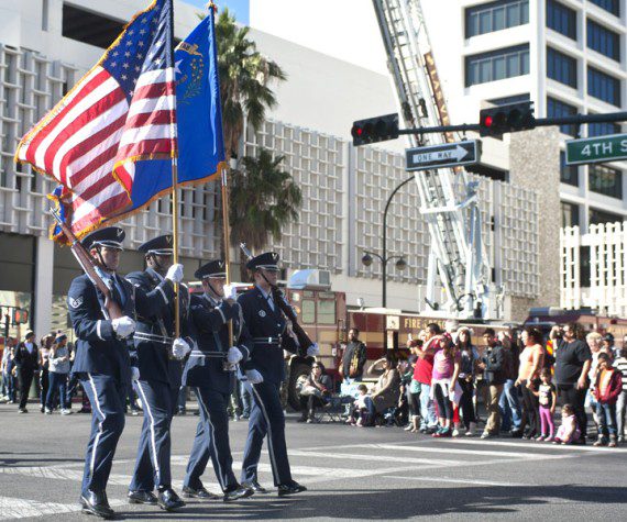 Airmen, Nellis Honor Guard, march down 4th Street during the Las Vegas Veteran's Day Parade Nov. 11, 2013, in Las Vegas. Brig. Gen. Stephen Whiting, U.S. Air Force Warfare Center vice commander, provided opening remarks during the parade and redeploying Airmen participated and waved at spectators. (U.S. Air Force photo by Staff Sgt. Christopher Hubenthal)