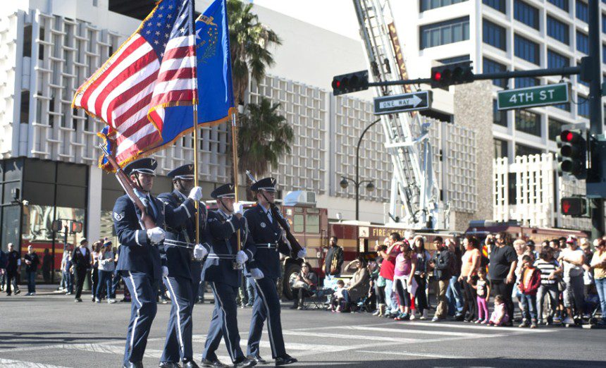 Airmen, Nellis Honor Guard, march down 4th Street during the Las Vegas Veteran's Day Parade Nov. 11, 2013, in Las Vegas. Brig. Gen. Stephen Whiting, U.S. Air Force Warfare Center vice commander, provided opening remarks during the parade and redeploying Airmen participated and waved at spectators. (U.S. Air Force photo by Staff Sgt. Christopher Hubenthal)