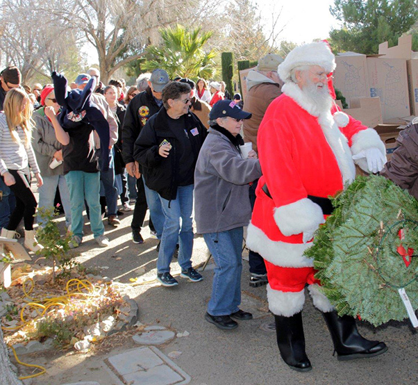 Photograph by Linda KC Reynolds Santa Claus and more than 100 volunteers help place wreaths on veteran’s graves during a Wreaths Across America event at the Lancaster Cemetery. To date, 855 veterans are buried at the cemetery, many still without headstones.