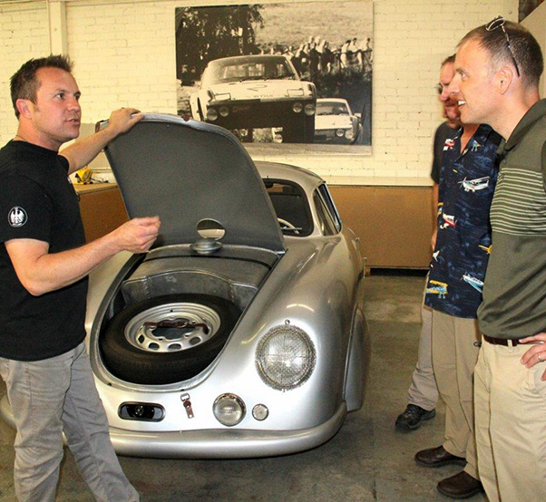 Photograph by Linda KC Reynolds Rod Emory (left) of Emory Motorsports shows Lt. Col Mark Massaro, Commander of the 412th Operations Support Squadron, how his team handcrafts rare Porsches and builds a 356 Outlaw class, combining the nostalgic look with the modern driveline and suspension. Emory’s team restored the 1949 Porsche Gmund SL 356/2 that won its class in the 1951 Le Mans. It is considered priceless and the most significant Porsche in the world.