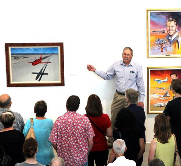 Photograph by Linda KC Reynolds Cam Martin, curator of NASA Armstrong’s fine arts program, gave a special narrated tour at Lancaster’s Museum of Art and History which displayed more than five dozen pieces of aviation art commemorating Armstrong’s 70th anniversary. On public display for the very first time were California artist Robert Schaar’s 17-painting series of NACA and NASA test pilots featured in Lancaster’s “Aerospace Walk of Honor.” 