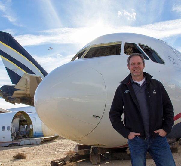 Photograph by Linda KC Reynolds Doug Scroggins of Scroggins Aviation stands in front of the Airbus A320-214, the fuselage was used in the movie Sully, a story of Chesley Sullenberger, an American pilot who became a hero after landing his damaged plane on the Hudson River in order to save the flight's passengers and crew.