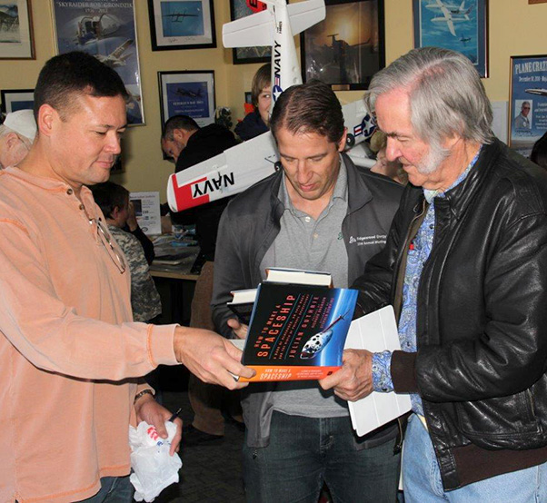 Photograph by Linda KC Reynolds World-renowned aircraft designer Burt Rutan autographs “How to Make a Spaceship” during an event at the Mojave Air and Space Port celebrating the 30th anniversary of the historic, record-breaking Voyager flight. Author Julian Guthrie, was also at the event selling and autographing books. To have subjects of the book available for autographs, plus the author, made great Christmas presents.
