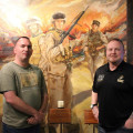 Photograph by Linda KC Reynolds Sean Flaharty, historian and logistics director of the Eyes of Freedom and gallery director Marine veteran Mark Strahle, stand before a painting of solders from Lima Company 3/25. The reserve unit, mostly from Ohio, lost 23 members between May and August 2005 in Iraq.