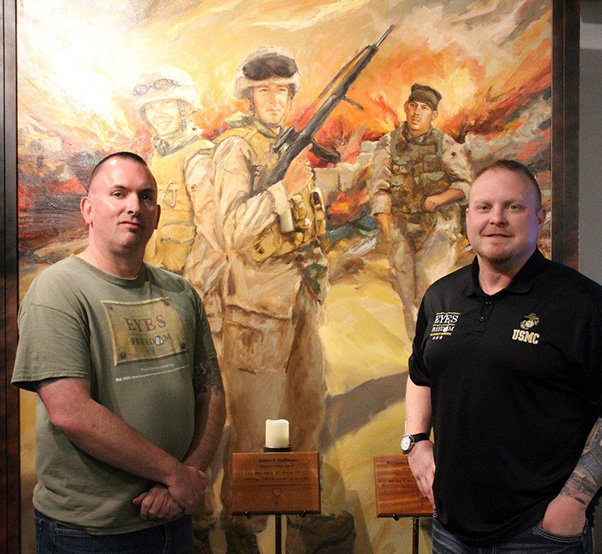 Photograph by Linda KC Reynolds Sean Flaharty, historian and logistics director of the Eyes of Freedom and gallery director Marine veteran Mark Strahle, stand before a painting of solders from Lima Company 3/25. The reserve unit, mostly from Ohio, lost 23 members between May and August 2005 in Iraq.