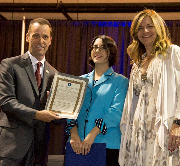 Photo by Linda KC Reynolds Board of Directors for the Flight Test Historical Foundation, Chairwoman Lisa Gray (right) presents Lisa Brown the Volunteer of the Year award for her outstanding contributions in the development of the curriculum for the online Junior Test Pilot School and on-site, eight week summer program at the Blackbird Airpark in Palmdale Calif., where children learned the fundamentals of flight with hands-on experiments. Guest teachers included test pilots and engineers. 