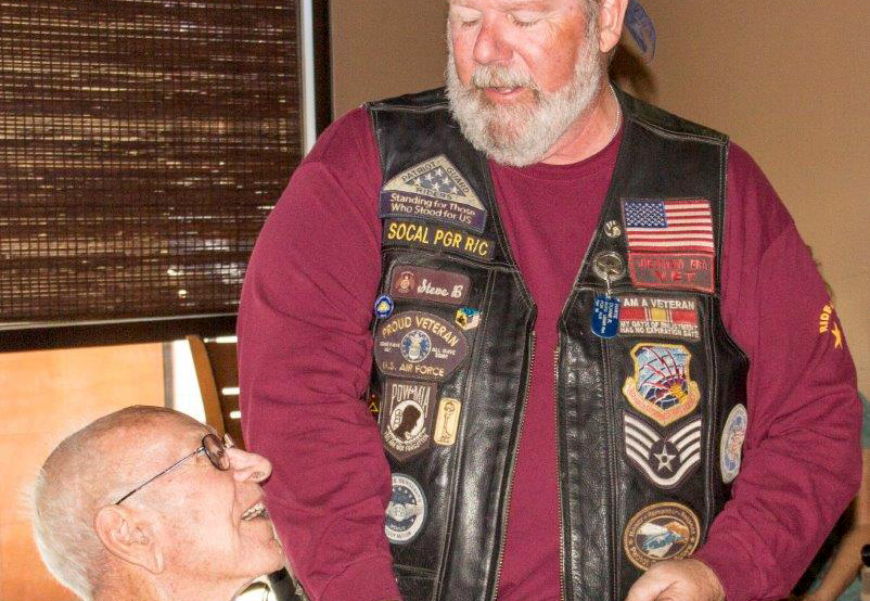 Photograph by Linda KC Reynolds World War II Veteran Capt. Robert “Bomber Bob” Wood receives a “First Ride” coin from Patriot Guard Steve Blumenfield. Blumenfield said it was an honor, and a nice change, to escort veterans who are still alive.