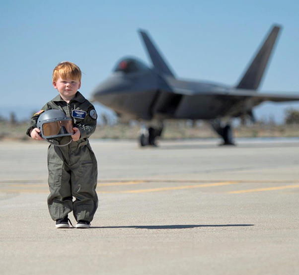 Photograph bb Linda KC Reynolds Who is that boy? Bryce Sanden, 4, is the grandson of Bob and Cathy Driver, both Lockheed Martin employees, who host the Photo Tour at the LA County Air Show at General William J. Fox Airfield. This photograph was taken during Family Day at Plant 42 and became an instant hit and is being used in print advertising and billboards. Bryce now sits alongside legends and autographs photos drawing a smiley face until he can master his penmanship.