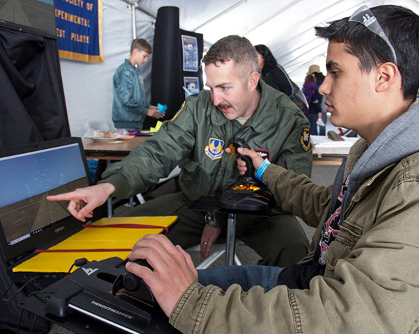 Photograph by Linda KC Reynolds Lt. Col. Paul Calhoun Command of the 418 Flight Squadron at Edwards Air Force Base teaches Rosamond High School student, Wesley Karkiewicz, 17, how to maneuver an F-4 during the 5th Annual LA County Air Show at General William J. Fox Airfield. Karkiewicz started the robotics program at his school and plans on becoming an Air Force fighter pilot.