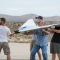 NASA photograph by Lauren Hughes Al Bowers, center, and a group of student interns hook up a bungee cord for a flight of the Prandtl-D 3C subscale glider aircraft.