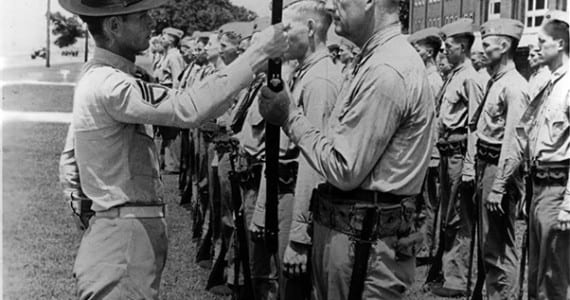 Pvt. Paul Douglas, age 50, preforms a rifle inspection with his drill instructor aboard Marine