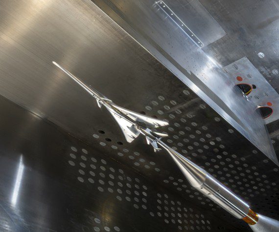 The X-59 small-scale model is seen in NASA Glenn’s 8- by- 6-foot Supersonic Wind Tunnel. The model was inverted with the shock wave sensor array mounted on the tunnel’s ceiling during the testing. (NASA photograph)