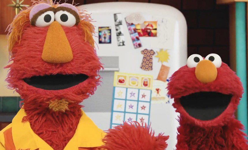 A video still shows the Muppet Elmo and his father.