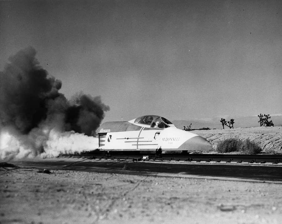 The F-101A ejection seat on a train rail with a lot of smoke blowing out in the back
