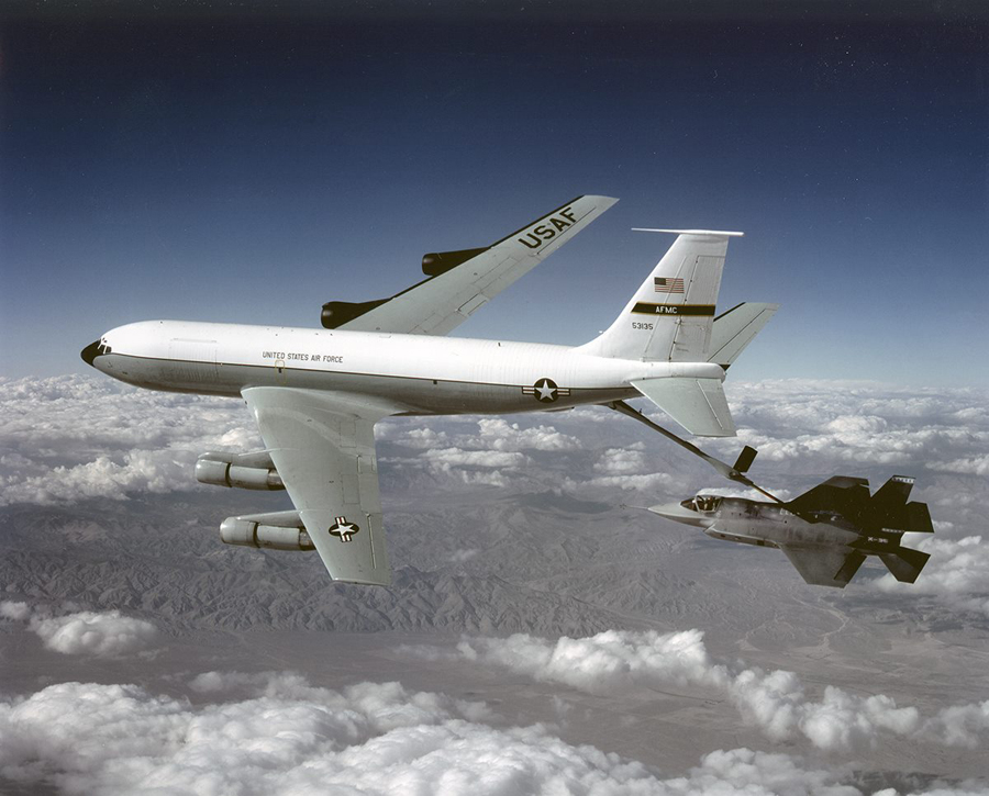 A color image of a X-35A and another airplane connected by a gas line in flight