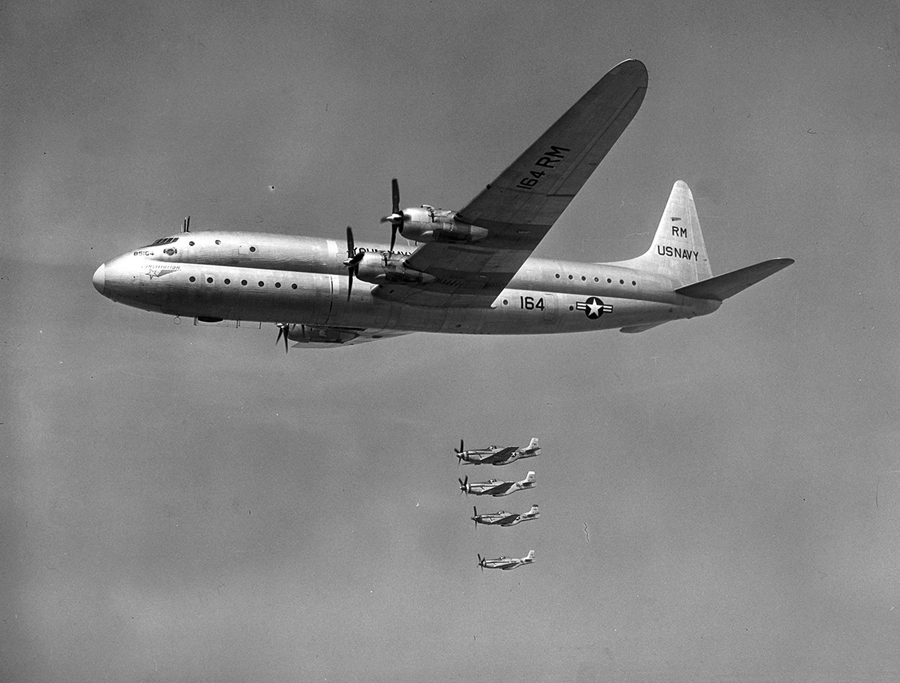 A black and white image of a XR60-1 Constitution in flight with four other similar planes father in the background