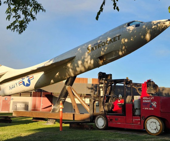 The Douglas D-558-II Skyrocket at Antelope Valley College on Friday night, with the specialty lifting fixture attached. The brown metal fixture was custom fabricated by Coast Machinery Movers to allow the Versalift to move the airplane. Steel plates were laid at the rear of the Versalift to protect the grass from the heavy equipment. The plane will be refurbished and reinstalled in a new location after campus construction is finished. (Photo by Lisa Kinison)