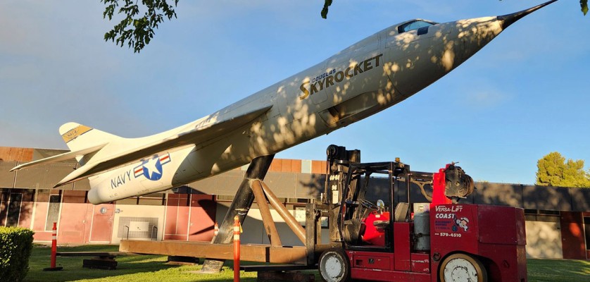 The Douglas D-558-II Skyrocket at Antelope Valley College on Friday night, with the specialty lifting fixture attached. The brown metal fixture was custom fabricated by Coast Machinery Movers to allow the Versalift to move the airplane. Steel plates were laid at the rear of the Versalift to protect the grass from the heavy equipment. The plane will be refurbished and reinstalled in a new location after campus construction is finished. (Photo by Lisa Kinison)