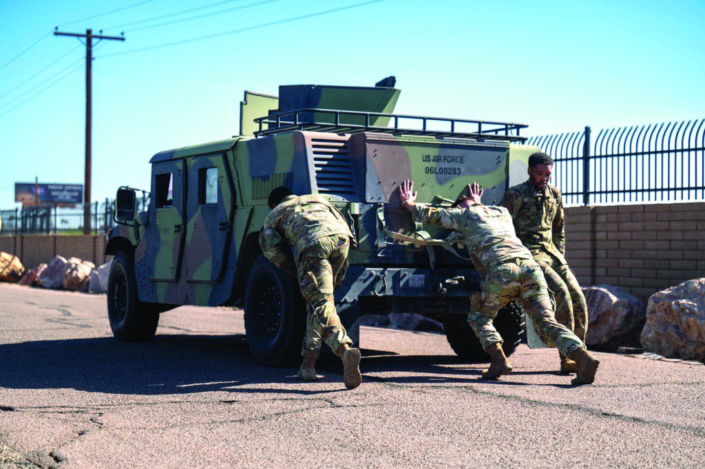 U.S. Air Force Airman 1st Class Jaylen Craig (left), Senior Airman Jason Wright (center), and Airman 1st Class Jren Jordan (right), 56th Security Forces Squadron defenders, push a Humvee during the 2025 Police Week Defender Challenge, May 13, 2025, at Luke Air Force Base, Arizona. The Defender Challenge consists of various strength and endurance trials, including tire flips, casualty movements, and ammo can presses.