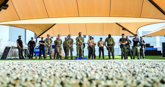 U.S. Air Force Airmen assigned to the 56th Fighter Wing and civilian law enforcement officers await the start of a K-9 competition, May 14, 2025, at Luke Air Force Base, Arizona. The 56th FW held various events throughout Police Week to commemorate fallen defenders and honor current security forces and civilian officers. These individuals keep the base and community safe every day of the week.