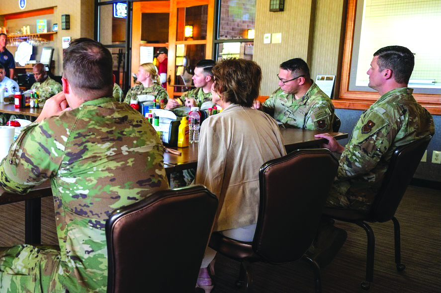 Janine Sijan-Rozina, Capt. Lance P. Sijan’s sister, sits with U.S. Air Force Airmen assigned to the 56th Fighter Wing during a lunch event held in honor of her brother, Medal of Honor recipient Capt. Lance Sijan, May 16, 2025, at Falcon Dunes Golf Course, Luke Air Force Base, Arizona. Capt. Lance Sijan died while being held as a prisoner of war during the Vietnam War, and he is the first Air Force Academy graduate to receive the Congressional Medal of Honor. Sijan was shot down over Vietnam on Nov. 9, 1967. Despite severe injuries, he evaded capture for 45 days, later passing away while being held at the infamous Hanoi Hilton. Sijan was posthumously awarded the Medal of Honor for his heroism.
