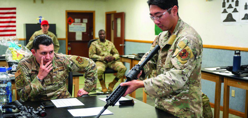 Members of the 56th and 944th Security Forces Squadrons watch as U.S. Air Force Staff Sgt. Casey Kaneshiro, 309th Aircraft Maintenance Unit weapons load crew member, disassembles an M4 carbine during a manipulation competition for National Police Week, May 14, 2025, at Luke Air Force Base, Arizona. Participants conducted timed disassembly, reassembly, and function drills of the M4 carbine and M17 pistol for a chance to win prizes.
