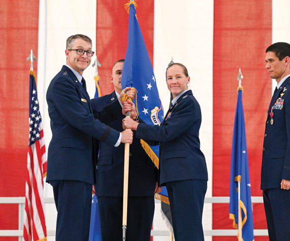 Maj. Gen. Scott Cain, Air Force Test Center commander, passes the guidon to Col. Maryann Karlen, Test Pilot School commandant, during the change of command ceremony at Edwards Air Force Base, Calif., June 13, 2025. The event marked a new chapter in TPS leadership and ongoing innovation. (U.S. Air Force photo by MSgt. Tabatha Arellano)