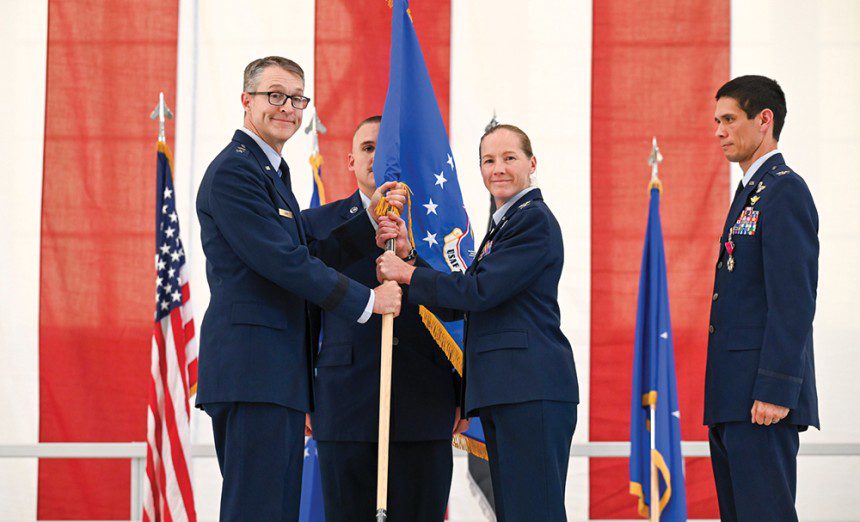 Maj. Gen. Scott Cain, Air Force Test Center commander, passes the guidon to Col. Maryann Karlen, Test Pilot School commandant, during the change of command ceremony at Edwards Air Force Base, Calif., June 13, 2025. The event marked a new chapter in TPS leadership and ongoing innovation. (U.S. Air Force photo by MSgt. Tabatha Arellano)