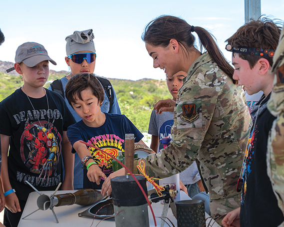 U.S. Air Force Airman 1st Class Gianna Baldizzi, 355th Civil Engineer Squadron explosive ordnance disposal technician, answers questions about different types of ordnance at Oracle, Arizona, June 12, 2025. Campers rotated through stations and activities to learn the roles Airmen play in supporting and sustaining the Air Force mission. (U.S. Air Force photo by Senior Airman Jasmyne Bridgers-Matos)